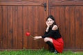 Portrait of dreaming pretty young teen girl with red tulip by gate Royalty Free Stock Photo