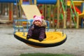 Portrait of dreaming three year old toddler girl with colorful braided hair, swinging outdoor Royalty Free Stock Photo