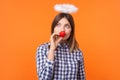 Portrait of dreamy angelic woman with brown hair wearing checkered shirt.  on orange background Royalty Free Stock Photo