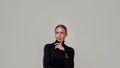 Portrait of dreamy caucasian young woman wearing black turtleneck holding finger near her face, looking thoughful aside