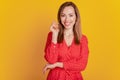 Portrait of dreamy coquette woman toothy smile in red dress on yellow wall