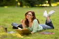 Portrait Of Dreamy Student Girl In Eyeglasses Studying Outdoors, Reading Book