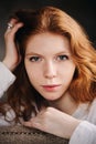 Portrait of dreamy young beautiful redhead woman relaxing at home