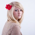 Portrait of a dreamy young girl with a red gerbera flower in long blonde hair, looking at camera. Beautiful summer Royalty Free Stock Photo