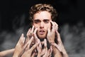 Portrait, drug addict and man with hands in studio isolated on a black background. Face, smoke and person intoxicated