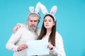 Portrait of Easter couple bunny woman and bunny man hold paper for text. Funny couple dressed in costume Easter bunny on Royalty Free Stock Photo