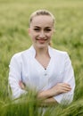 Portrait of Ecologist or biologist in a white coat and glasses examining plants