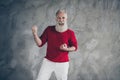 Portrait of ecstatic crazy white hair old man enjoy x-mas time win lottery celebration raise fists scream yeah wear red Royalty Free Stock Photo