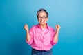Portrait of ecstatic funky cheerful person wear stylish blouse in eyewear clenching fists win betting isolated on blue Royalty Free Stock Photo
