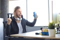 Portrait of ecstatic gamer guy in headphones screaming and rejoicing while playing video games on computer