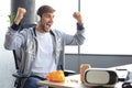 Portrait of ecstatic gamer guy in headphones screaming and rejoicing while playing video games on computer