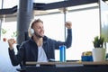 Portrait of ecstatic gamer guy in headphones screaming and rejoicing while playing video games on computer