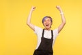 Portrait of ecstatic joyful hipster girl standing with her fists raised and shouting enthusiastically. studio shot