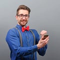 Portrait of ecstatic man holding cell phone and celebrating with closed fist against gray background Royalty Free Stock Photo