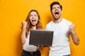 Portrait of ecstatic man and woman shouting and clenching fists