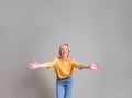 Portrait of ecstatic young blond businesswoman with arms outstretched standing on white background Royalty Free Stock Photo