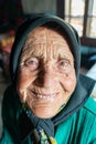 Portrait of an elder woman smiling in traditional old home and traditional clothes, Roumania Maramures County