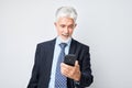 Portrait of elderly businessman in suit holding mobile phone in hand with happy smiling face. Person with smartphone Royalty Free Stock Photo