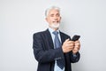 Portrait of elderly businessman in suit holding mobile phone in hand with happy smiling face. Person with smartphone Royalty Free Stock Photo