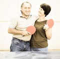 Portrait of elderly couple with rackets for table tennis