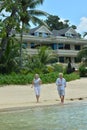 Portrait of elderly couple running on tropical beach Royalty Free Stock Photo