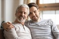 Portrait of elderly father and adult son hugging