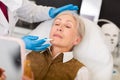 Elderly wman receiving procedure of face mesotherapy at cosmetology clinic