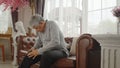 Asian senior man sitting on sofa and massage his knee Royalty Free Stock Photo