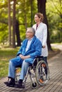 Portrait of elderly man on wheelchair with nurse outdoor Royalty Free Stock Photo