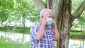 Portrait of Elderly old Asian man taking off face mask in the park after The epidemic situation resolved after There are vaccines