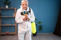 portrait of Elderly pest control worker killing insects asking help me please inside infested house. Exterminator in protective Royalty Free Stock Photo