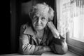 Portrait of an elderly sad woman, monochrome photo.