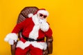 Portrait of elderly santa claus thinking sit armchair which gifts bring from north pole on xmas night isolated over