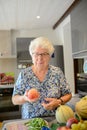 Portrait of elderly senior woman cooking fresh vegetables in her kitchen at home Royalty Free Stock Photo