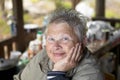 Portrait of an elderly woman. Bright expressive eyes. She smiles. The background is blurred