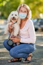 Portrait elderly woman with a dog outdoors an antivirus mask Royalty Free Stock Photo