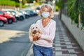 Portrait elderly woman with a dog outdoors an antivirus mask Royalty Free Stock Photo