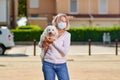 Portrait elderly woman with a dog outdoors an antivirus mask Royalty Free Stock Photo