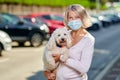 Portrait elderly woman with a dog outdoors an antivirus mask Royalty Free Stock Photo