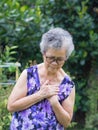 Portrait of an elderly woman having a heart attack. A senior woman clutching her chest in pain at the first signs of angina Royalty Free Stock Photo