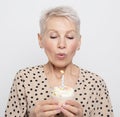 Portrait of elderly woman holding birthday cupcake celebrating anniversary. Royalty Free Stock Photo