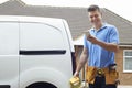 Portrait Of Electrician Checking Message On Mobile Phone