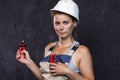 Portrait of Electrician female builder worker in uniform with wirecutter. Woman professional electric.