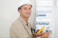 portrait electrician standing next to fuseboard