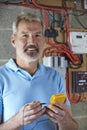 Portrait Of Electrician Standing Next To Fuseboard