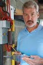 Portrait Of Electrician Standing Next To Fuseboard Royalty Free Stock Photo