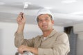 Portrait electrician working on light fitting