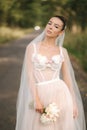 Portrait of elegand bride with bouquet. Young bride outdoors