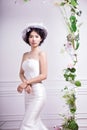 Portrait of elegant bride standing against white wall