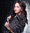 Portrait of elegant brunette retro woman wearing silver fox fur over vintage background